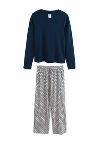 Marineblauw geribd shirt met lange mouwen en ronde hals gecombineerd met wijde broek met patroon met perzik- en blauwe geometrische vormen.