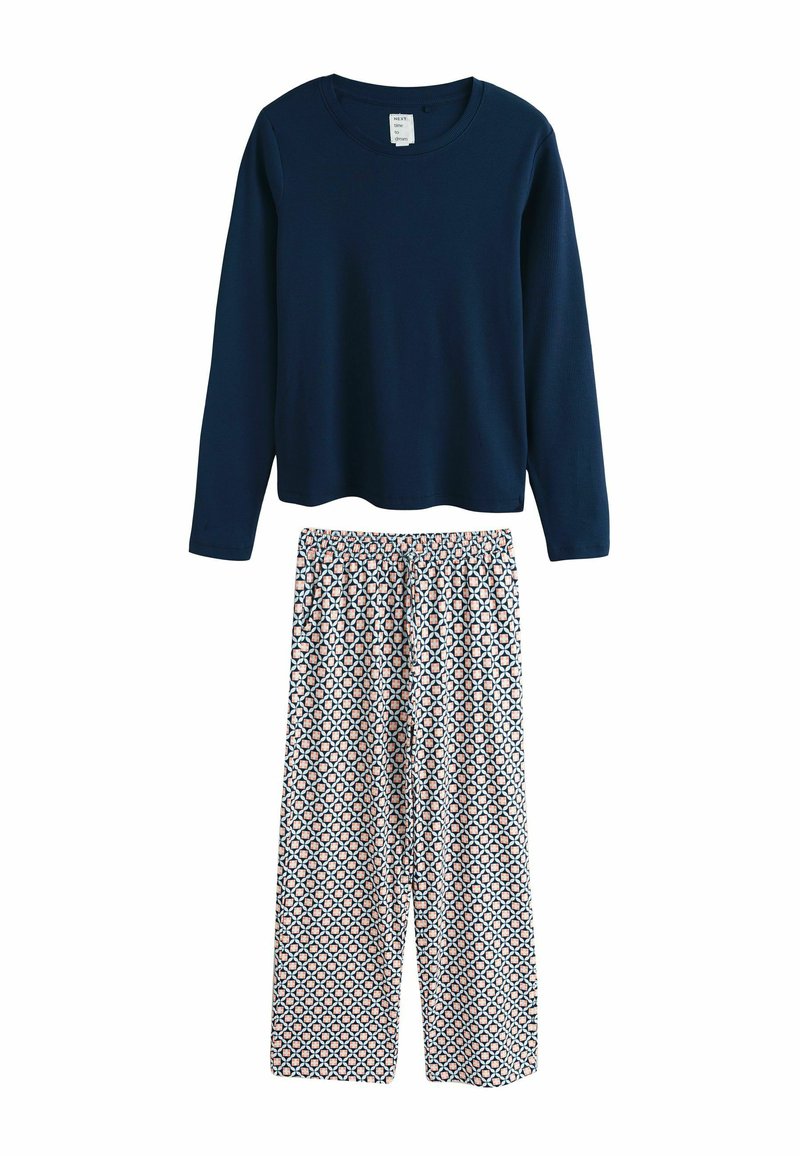 Marineblauw geribd shirt met lange mouwen en ronde hals gecombineerd met wijde broek met patroon met perzik- en blauwe geometrische vormen.