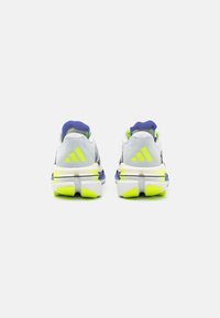 White and grey athletic shoes with purple and neon yellow accents; includes a cushioned sole and three-stripe branding on the heel.