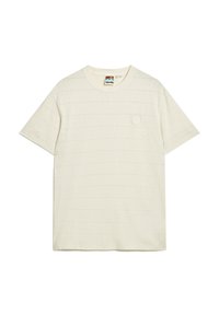 Camiseta de algodón color crema con mangas cortas, con sutiles rayas horizontales y un pequeño logo en parche en el lado izquierdo del pecho.