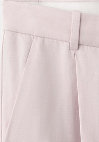 Pantalon rose clair ajusté en tissu texturé, avec une ceinture et des passants de ceinture.