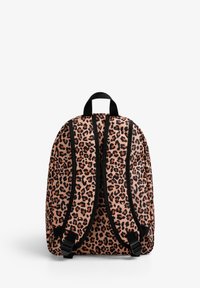 Mochila de estampado de leopardo con fondo rosa, correas negras y un asa en la parte superior. Presenta un diseño curvo y correas de hombro ajustables.