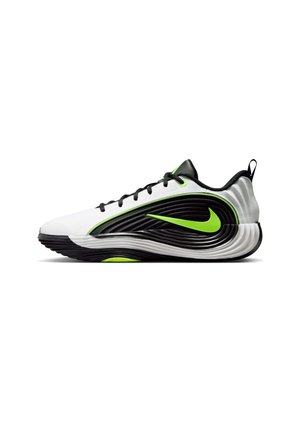 Pantof sport alb-negru Nike cu sigla verde neon, șireturi negre și talpă texturată ondulată, prezentat în profil lateral.