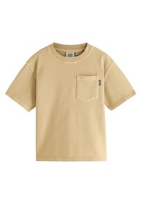 Kortärmad t-shirt med rund hals i ljusbeige, tillverkad av strukturerad bomull. Har en liten bröstficka med en etikett.