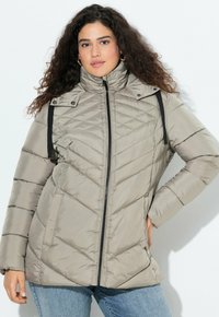 Giacca trapuntata grigia chiaro con colletto alto, chiusura zip e motivi a rombi, dotata di fasce nere sulle spalle e tasche laterali.
