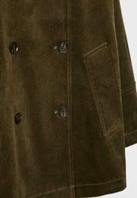 Braune Cordjacke mit doppelreihigem Design, schwarzen Knöpfen, einer aufgesetzten Tasche und vertikaler Ripptextur.