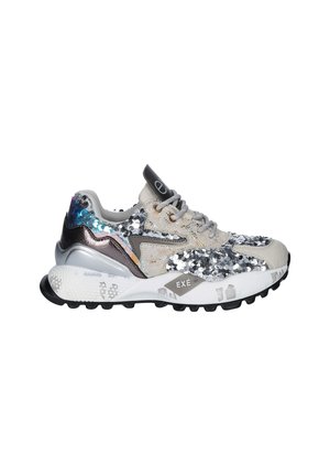 Deportiva gruesa con cordones grises, lentejuelas plateadas sobre tela beige, detalles metálicos azules y plateados en el talón, y suela blanca con dibujo negro.