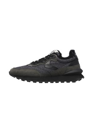 Sneaker grigio scuro e nero con tessuto strutturato, dettagli in pelle, suola spessa con battistrada e colletto imbottito visibili dal lato.