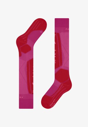 Rote und rosa gemusterte Socken mit einem geometrischen Design, die einen einfarbigen Bund und eine strukturierte Fußsohle aufweisen. Auf beiden Socken sind Etiketten angebracht.