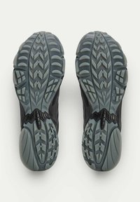 Black running shoes with textured gray soles featuring a prominent tread pattern and distinctive grooves for traction.