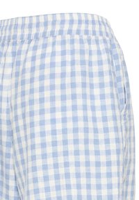 Lyseblåt og hvidt ternet stof med elastisk, rynket talje og lommedetalje i siden på løstsiddende beklædning.