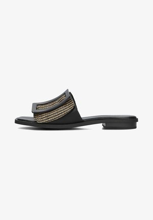 Zwarte teenslippers met een geweven gouden accent en een platte zool. Voorzien van een opvallende bovenband met een gebogen vorm en een strakke uitstraling.