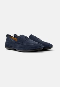 Mocasines de ante azul marino con suela de goma plana, que cuentan con un acento cosido en el empeine y un diseño sin cordones para un fácil uso.