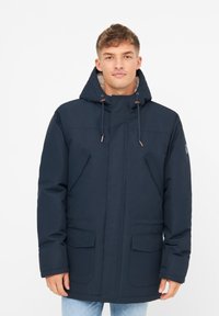 Chaqueta parka de color azul marino, fabricada con material impermeable, con capucha, bolsillos frontales y cordones ajustables. Interior forrado con textura suave.