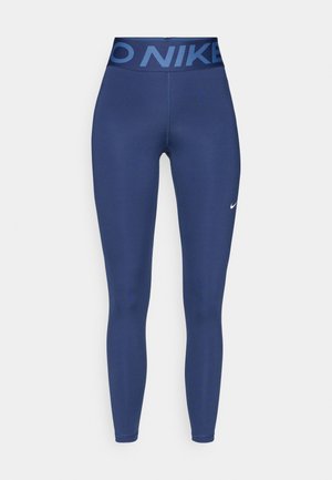Leggings azul marino con una cinturilla ancha y estampada que presenta el texto "NIKE". Tejido suave con un diseño ajustado y sin costuras visibles.