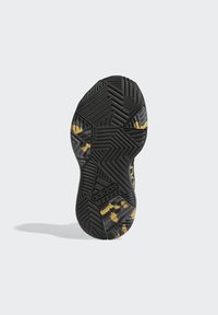 Black rubber sneaker sole with a zigzag tread pattern, featuring yellow accents and brand logo. Textured surface for traction.