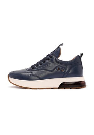 Zapatillas de piel navy con una media suela blanca y suela de goma marrón. Presentan cordones redondos, agujeros de ventilación laterales y un cuello acolchado.