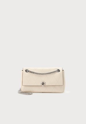 Sac à main en cuir matelassé crème avec rabat avant, bandoulière chaîne argentée et fermoir logo métallique sur fond uni clair.