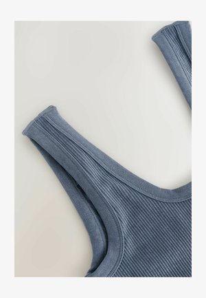 Top de tirantes azul con textura acanalada y tirantes anchos, con bordes terminados, dispuesto sobre un fondo claro.