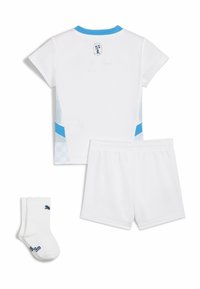 Conjunto atlético blanco que incluye una camiseta de manga corta con acentos azules, shorts a juego y calcetines blancos con un logo azul. Textura de tela suave.