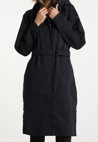 Manteau long noir imperméable avec une taille ceinturée, une capuche et des boutons latéraux. Présente un tissu lisse et un design épuré.