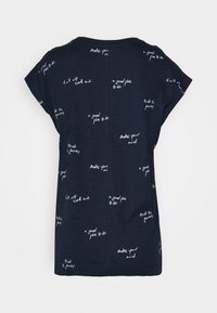 Camisa de manga corta azul marino con frases escritas a mano en blanco como "un buen lugar para estar", "confía en el viaje" y "forma tu mente".