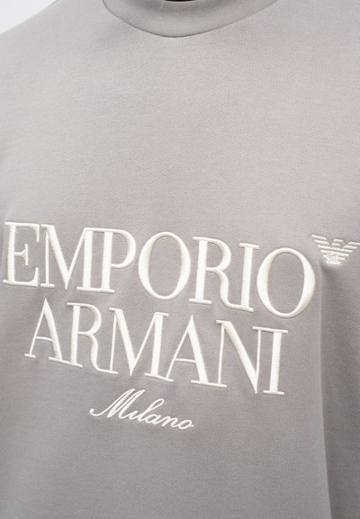 Sivá mikina s reliéfným bielym textom "EMPORIO ARMANI" a "Milano", s malým logom na pleci. Hladká textura.