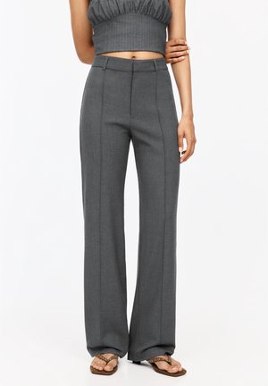 Pantaloni grigi a gamba larga con una texture liscia, caratterizzati da pieghe nette e una vestibilità sartoriale. Il tessuto presenta un motivo sottile che valorizza il design complessivo.