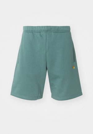 Cotton blend shorts in a teal color with an elastic waistband, side pockets, and a small gold logo accent on the lower leg.