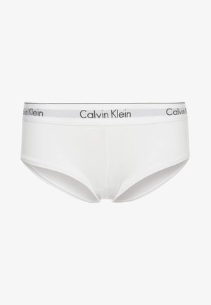 Beli bombažni bokser z oznako "Calvin Klein" na sivoj elastiki. Gladka tekstura, nizki kroj in klasična oblika.