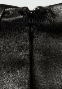 Materiale in pelle nera con finitura testurizzata, caratterizzato da una chiusura con zip centrale e dettagli di cucitura sottili lungo i bordi.