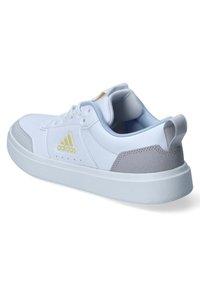 Scarpa sportiva bianca con tomaia in pelle liscia, accentata in suede grigio, linguetta imbottita e suola bianca texturizzata. Presenta un logo Adidas.