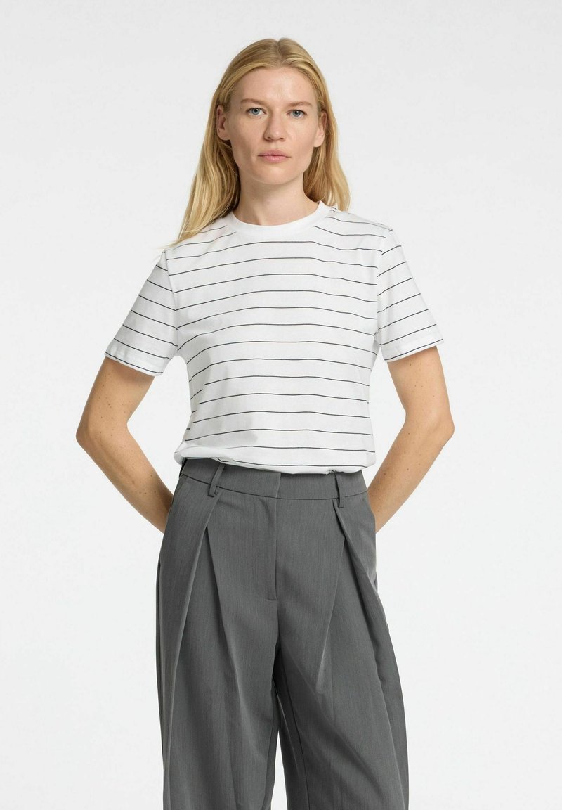 Vit kortärmad t-shirt med svarta horisontella ränder, rund halsringning och en avslappnad passform, kombinerad med grå högmidjade fickbyxor med veck.