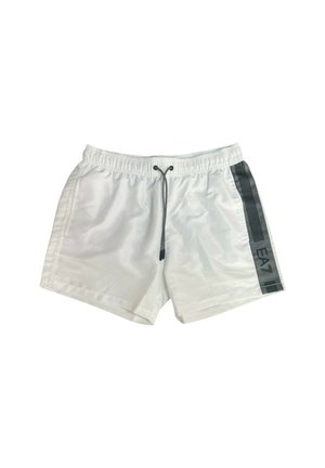 Pantaloni da bagno bianchi con cintura elasticizzata, cordino e striscia verticale nera con testo sul lato. Tessuto leggero, texture liscia.