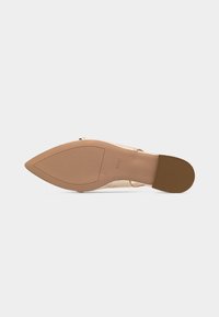 Chaussure pour femme beige à bout pointu vue par la semelle, indiquant la taille 5 et le nom de la marque "högl" sur un fond blanc.