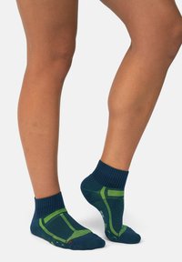 Calcetines deportivos azul y verde con puño acanalado, tejido texturizado y talón reforzado. Presentan rayas en contraste y áreas acolchadas para mayor comodidad.