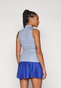 Sleeveless dress with a high collar, featuring a blue and white geometric pattern on the top and a pleated blue fabric skirt.