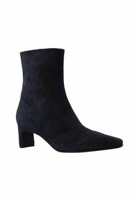 Marineblaues Wildleder-Ankle-Boot mit spitzem Zehenbereich und mittelhohem Blockabsatz, der eine glatte Textur und ein nahtloses Design aufweist.