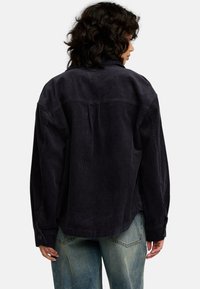 Donker marineblauwe corduroy shirt met een relaxte pasvorm, voorzien van een kraag, lange mouwen en een yoke-detail op de rug.