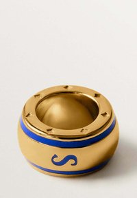Bowl decorativo dorado con un acabado suave, que presenta una franja azul y una letra "S" en relieve. Forma redonda con acentos de puntos.