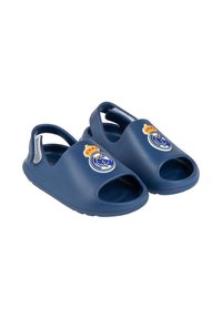 Granatowe plastikowe sandały z otwartymi palcami, z okrągłym logo Real Madryt i żółtą koroną. Lekkie, z teksturowaną podeszwą.