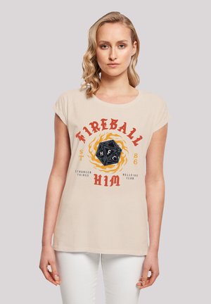 Beige T-Shirt mit kurzen Ärmeln, das einen Grafikdruck eines schwarzen Würfels, Flammen und roten sowie schwarzen Text enthält.