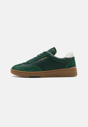 Sneaker verde con camoscio testurizzato e dettagli in pelle liscia, con una suola in gomma marrone e lacci verdi. Logo visibile sul lato.