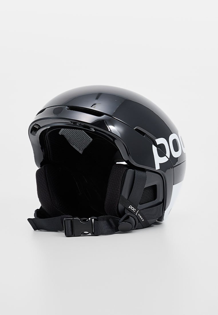 Czarny kask narciarski o połyskującej powierzchni. Posiada wyściółkę, regulowany pasek oraz otwory wentylacyjne. Logo umieszczone z boku.