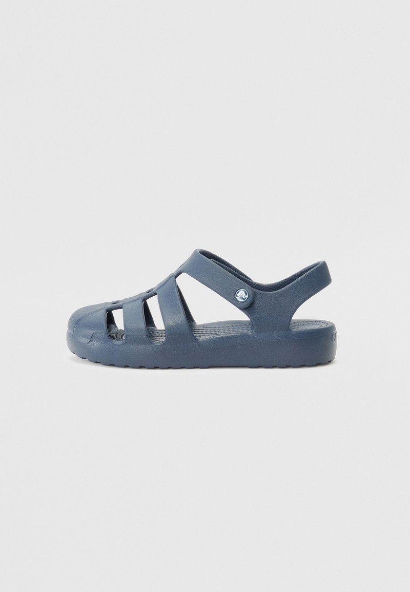 Niebieskie plastikowe sandały z otwartym wzorem, z bocznymi wycięciami, tylnym paskiem i teksturowaną wkładką. Podeszwa jest gruba z wzorami antypoślizgowymi.