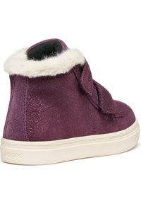 Zapato alto de ante púrpura impermeable con un cuello de piel blanca, correa de velcro y una suela de goma texturizada crema. Se puede ver la marca Geox.