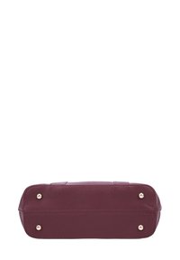 Sac à main en cuir bordeaux avec une forme rectangulaire, une surface texturée, des accents en métal doré, et quatre pieds de protection au bas.
