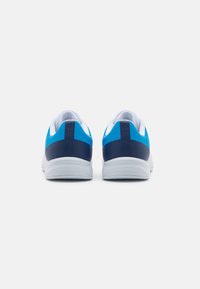 Blauwe en marineblauwe sportschoenen met een gestructureerde bovenkant en een witte zool, met een ronde hak en contrasterende kleuraccenten.