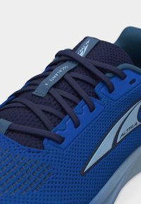 Μπλε και ναυτικό αθλητικό παπούτσι με μαύρα κορδόνια και ετικέτα «Escalante 4» στο αεριζόμενο πλέγμα πάνω μέρος, με λογότυπο «Altra» στη πλευρά.