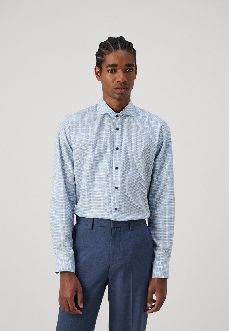 Lichtblauwe geblokte button-up shirt met een spreidkraag en donkere knopen, gecombineerd met donkerblauwe op maat gemaakte broeken. Glad fabric.